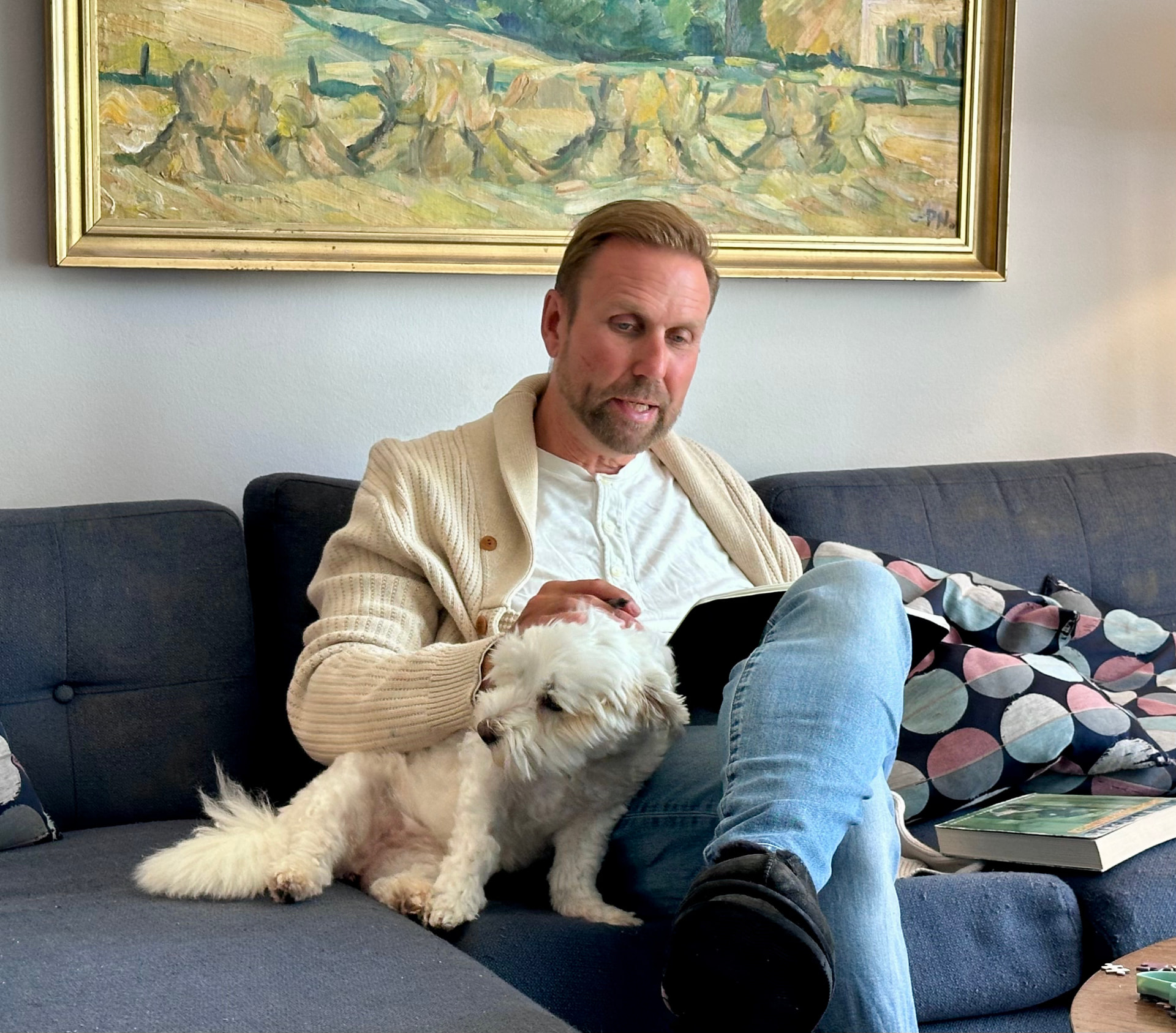 Ole Ditlev Nielsen læser i sofaen med sin hund