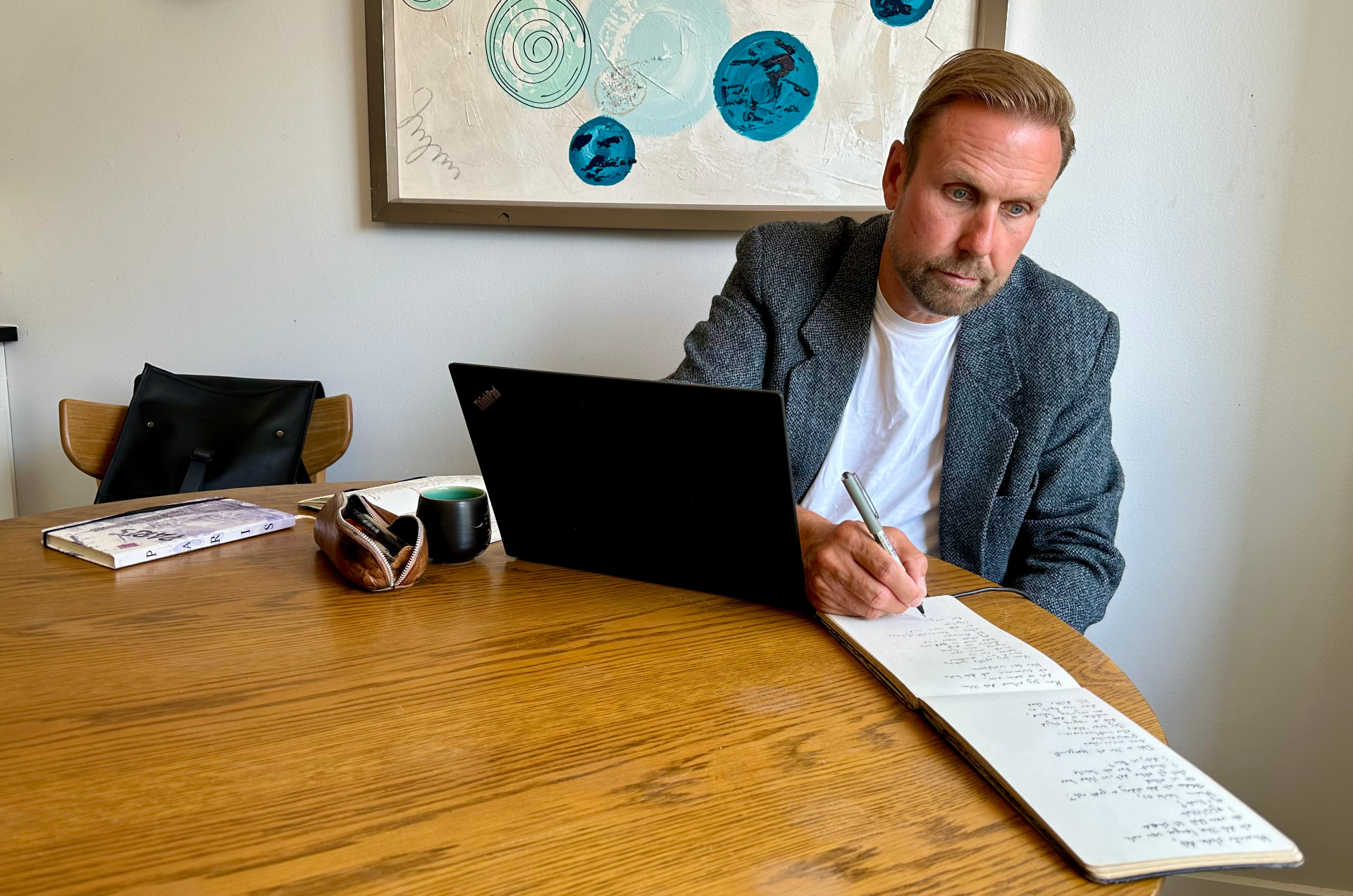 Ole Ditlev Nielsen skriver i sin notesbog ved skrivebordet